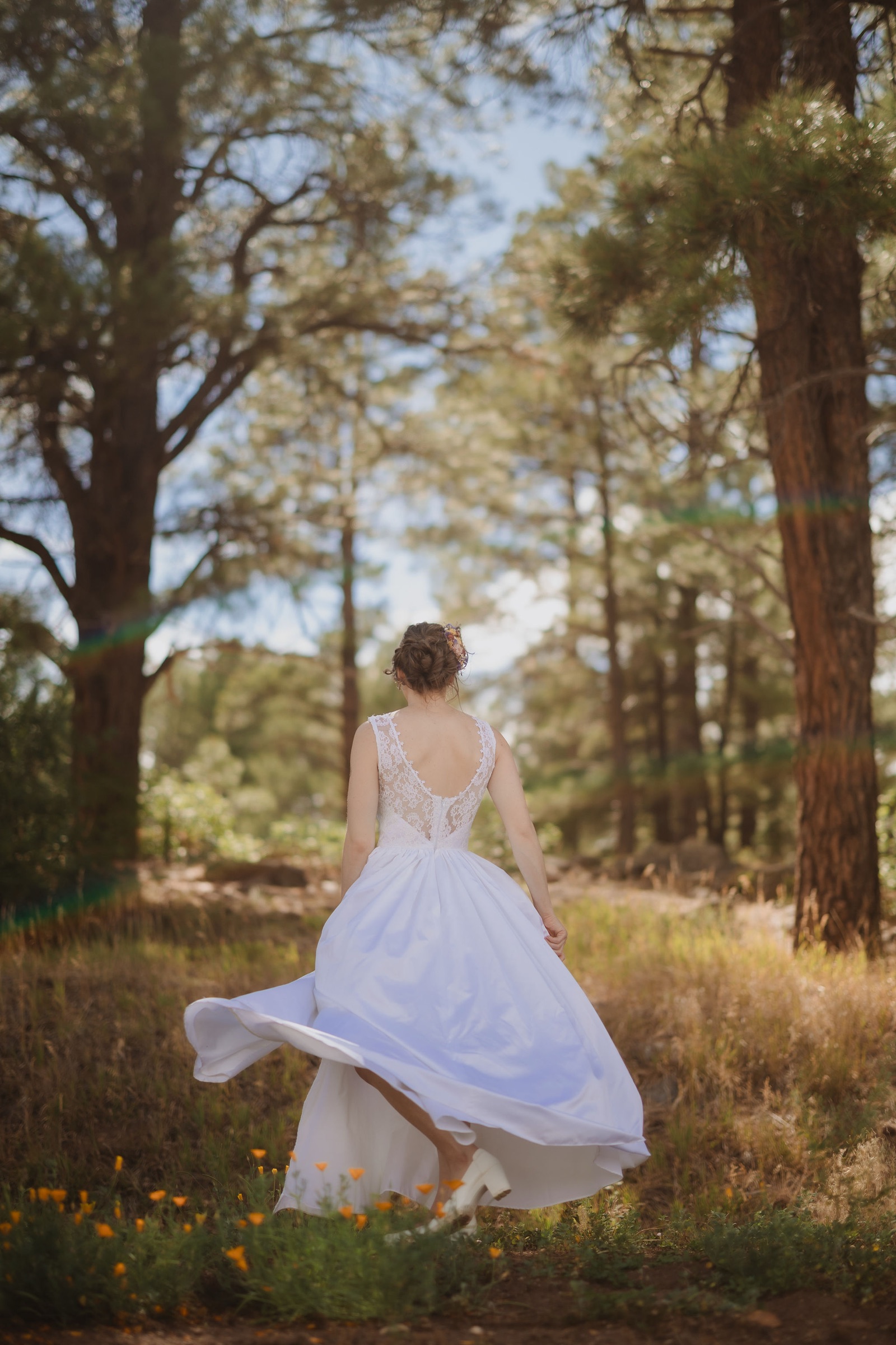 Kellie twirling in her wedding dress in the forest