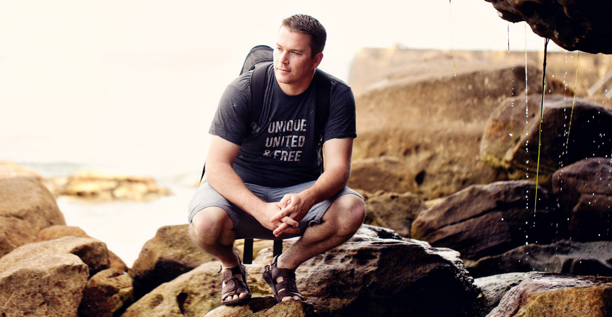 Trevor Dayley sitting near water with camera in hand