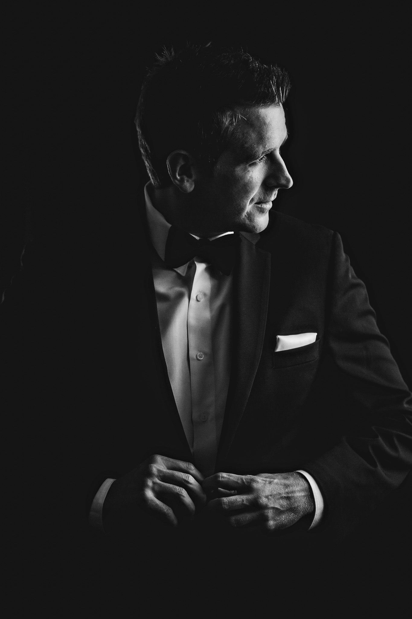 Black and white groom portrait in window light