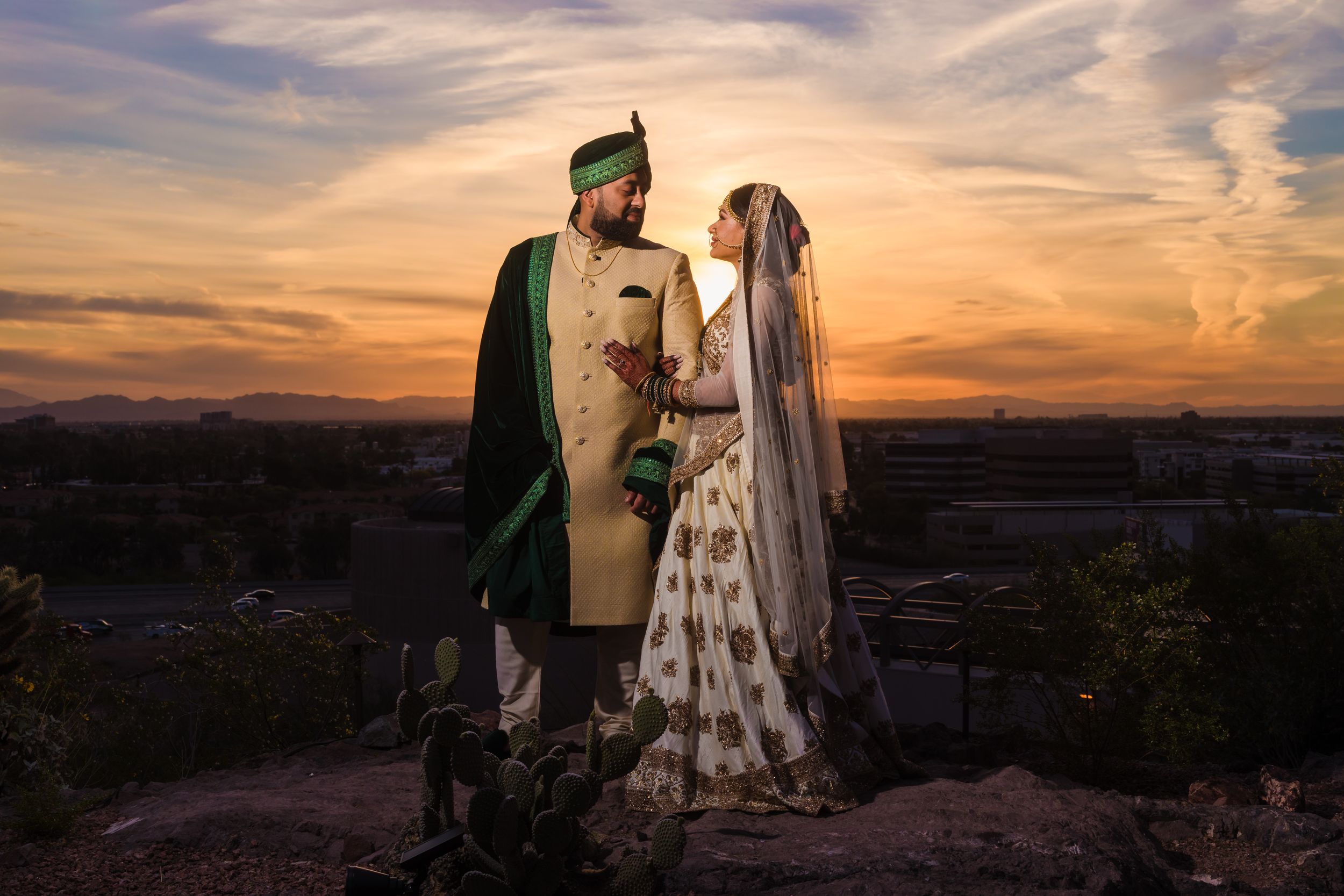 Couple photographed at sunset in traditional wedding attire