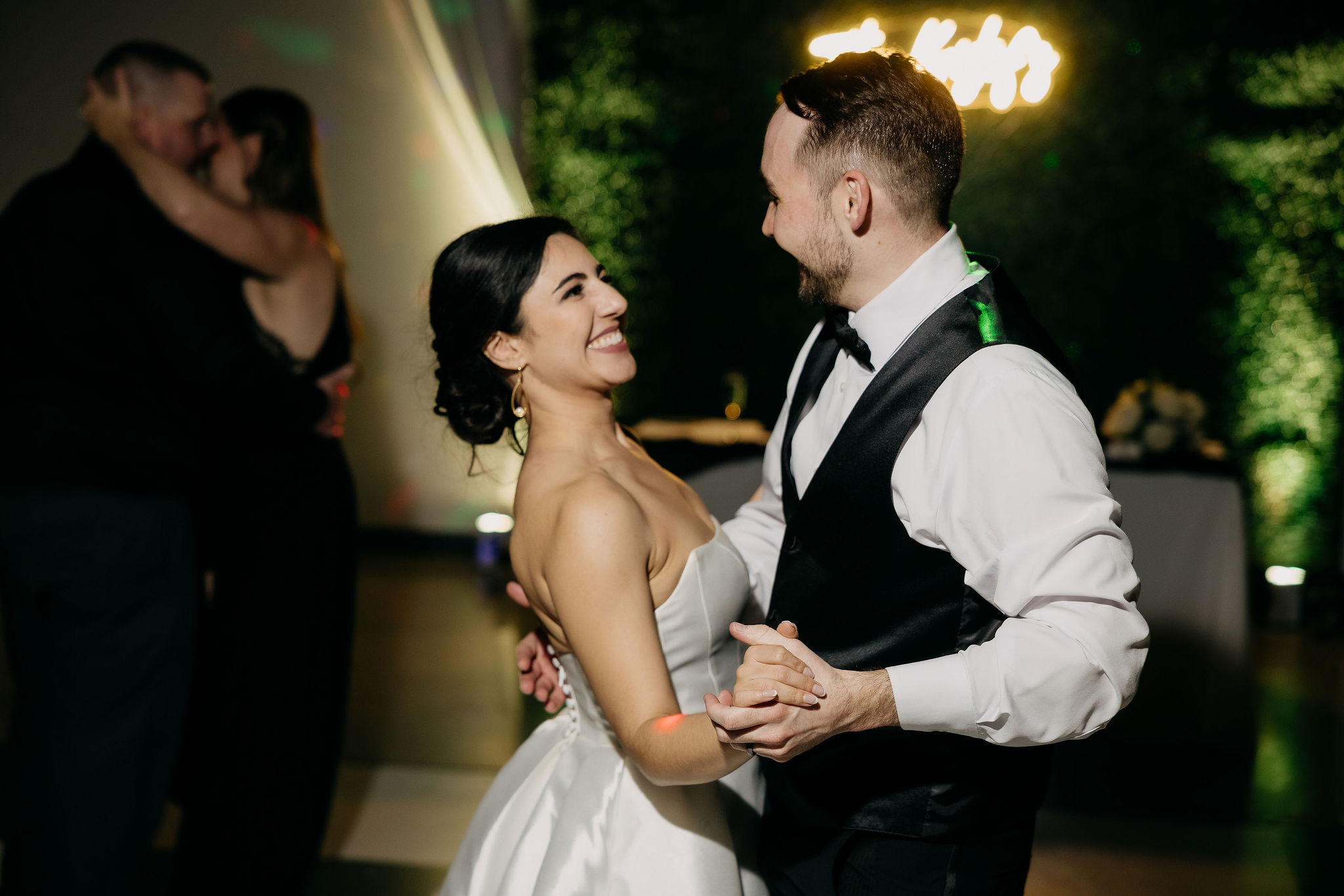 Alexa and Jerome dancing with glow foam sticks at the reception