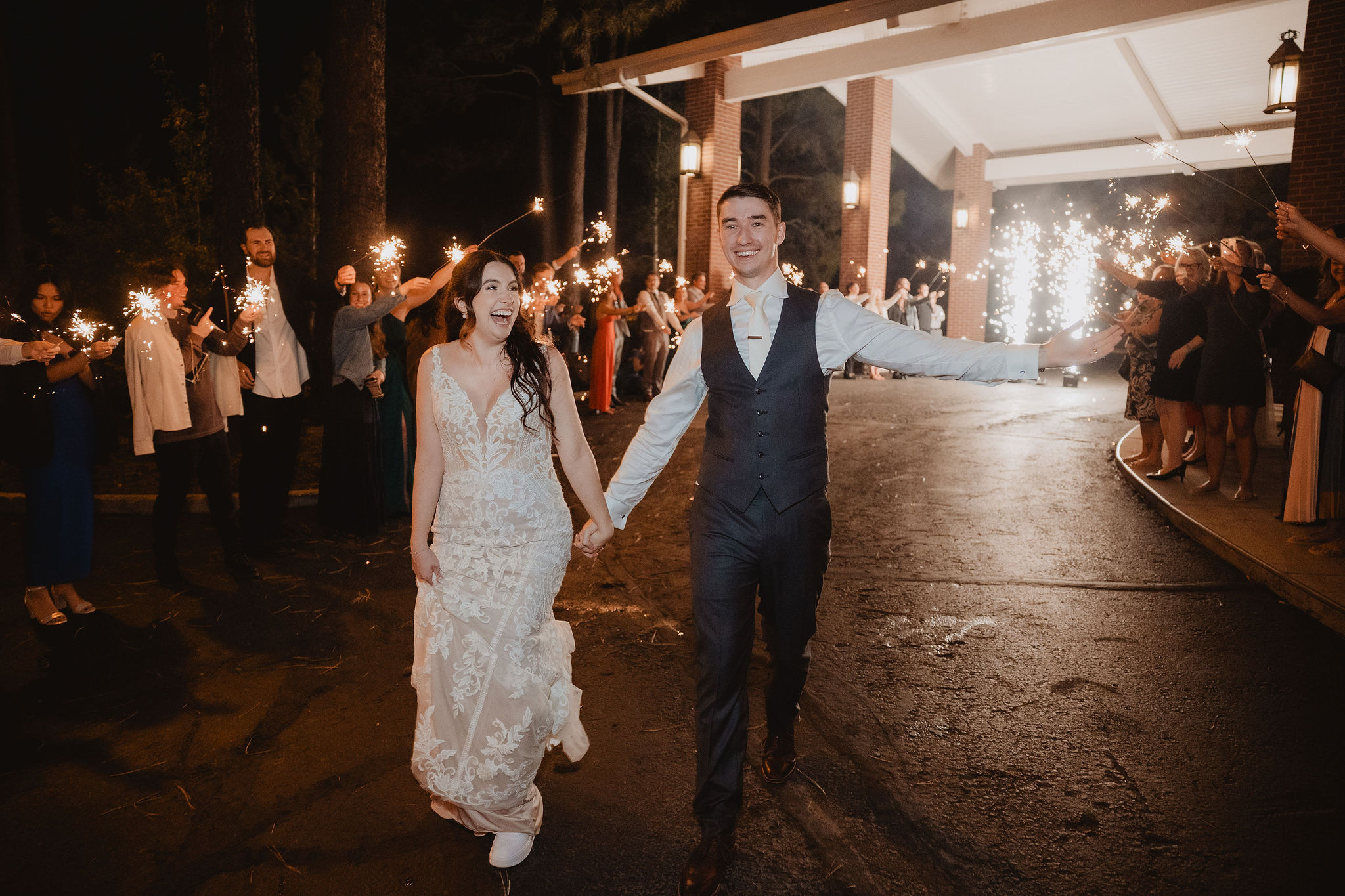 Brittney and Trevor walking through sparklers at Little America Hotel