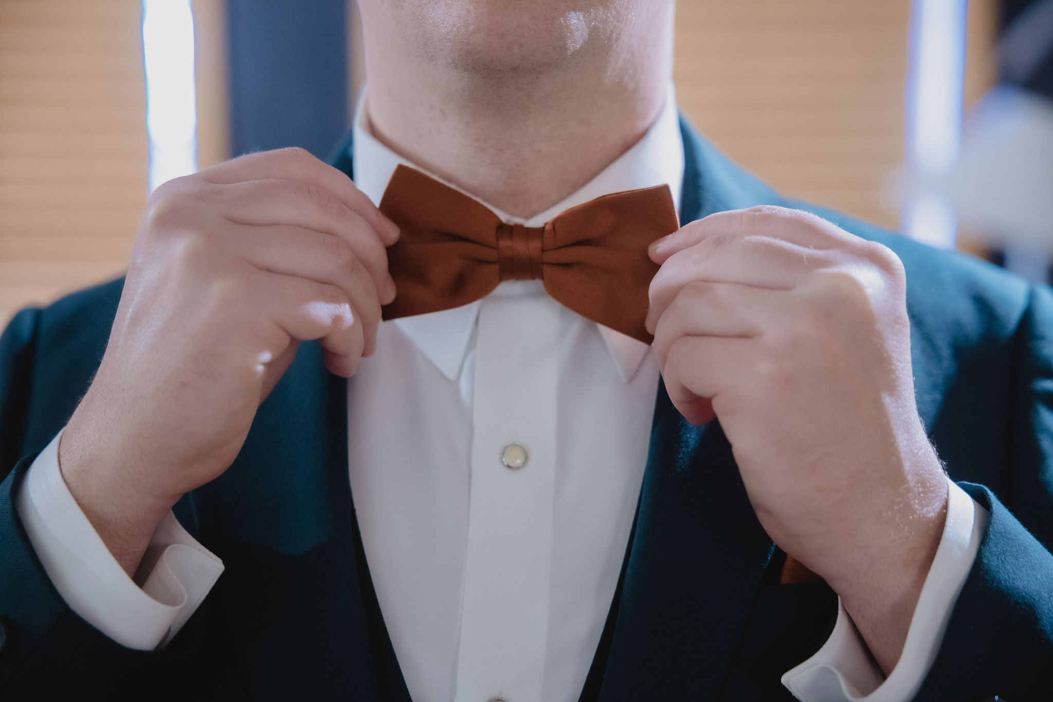 Jake adjusting his bow tie before the ceremony