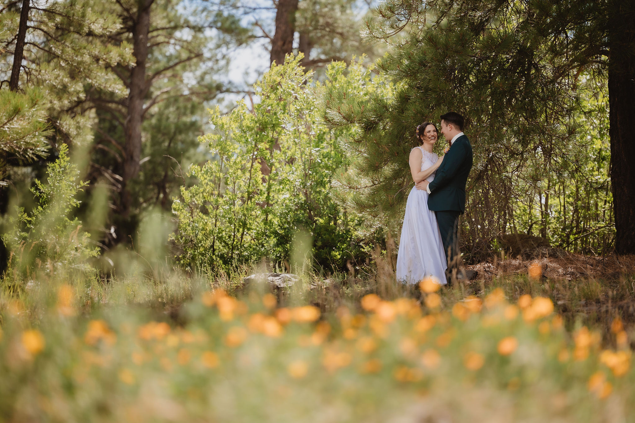 Kellie and Jake portrait with wildflowers and forest light