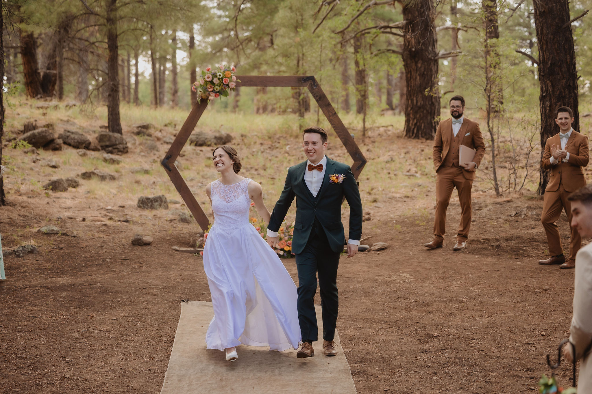 Kellie and Jake walking from the ceremony frame at Aldea in the Woods