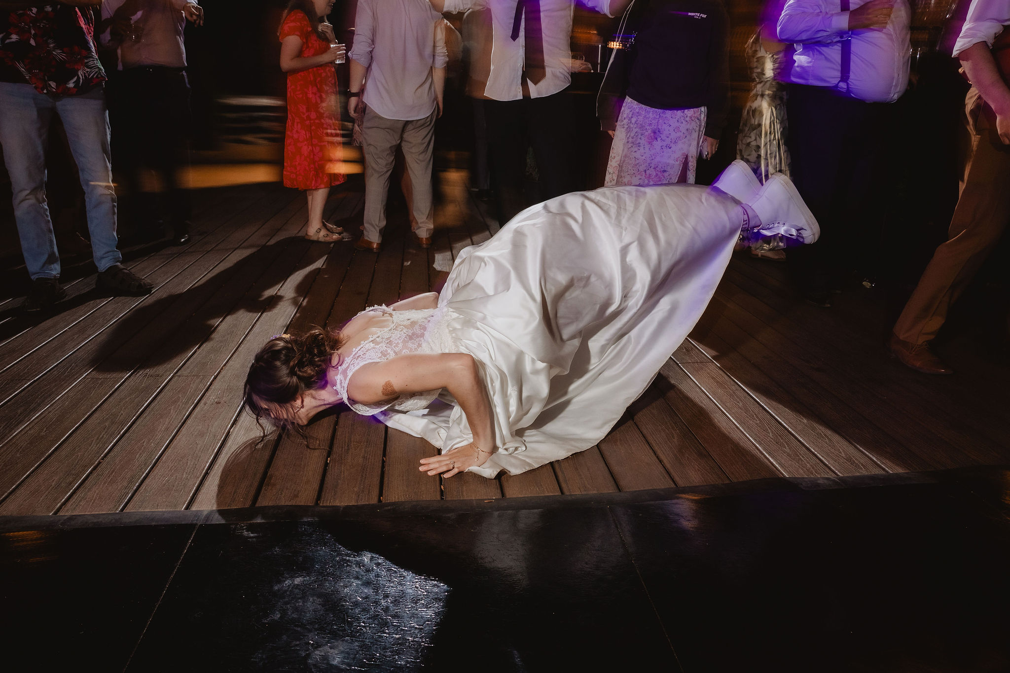 Reception guest sliding across the dance floor during the party